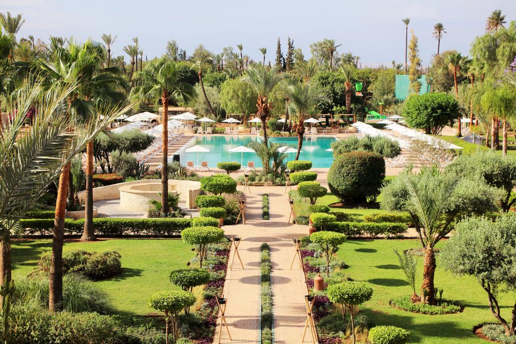 Kappa Club Iberostar à Marrakeck : vue du jardin avec piscine au centre et orné de palmiers.